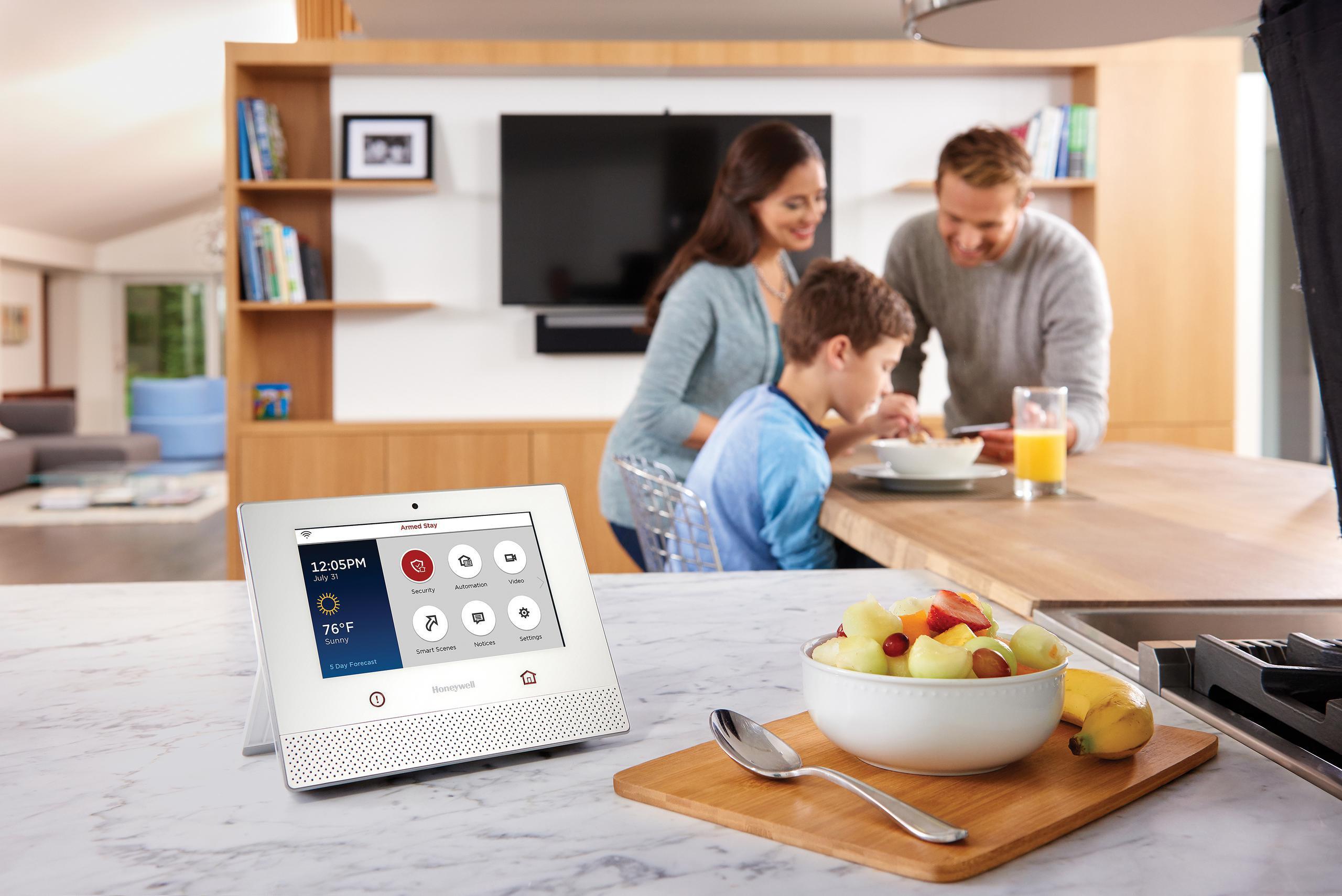 Family eating breakfast with a smart home automation console nearby